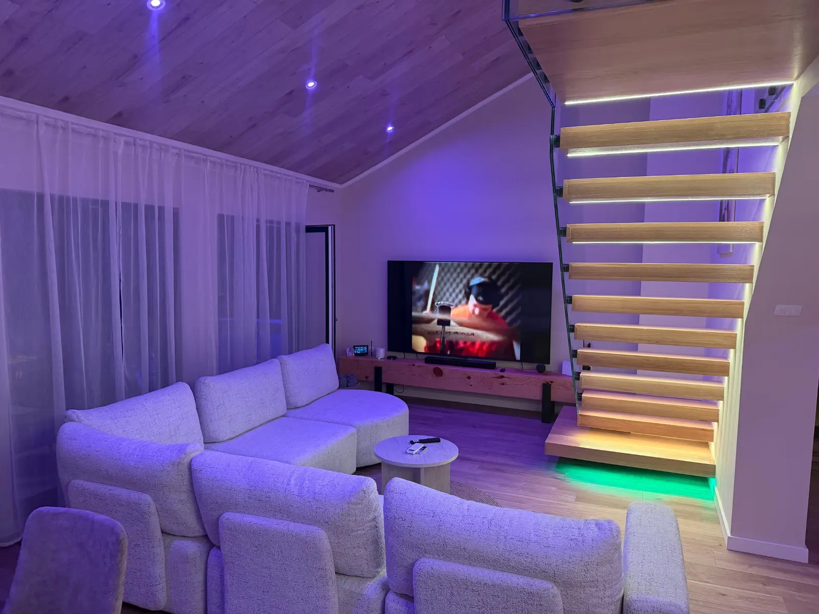 Smart TV beside the illuminated living room stairs